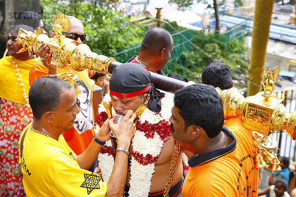 Heiliger Mann mit versiegeltem Mund und Last auf den Schultern  hinduistisches Thaipusam Fest  Tempel Batu Caves  Kalksteinhöhlen  Kuala Lumpur  Malaysia  Südostasien  Asien