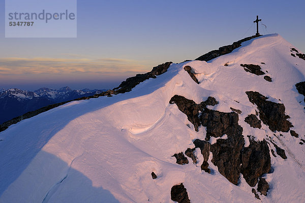 Winterlicher Gipfel mit Kreuz zur blauen Stunde  Reutte  Tirol  Außerfern  Österreich  Europa