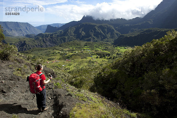 Wanderin blickt auf das abgelegene und schwer erreichbare Bergdorf Marla im Vulkankessel Cirque de Mafate  Marla  Insel La Reunion  Indischer Ozean