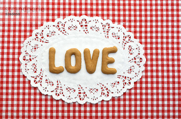 Love  geschrieben mit Buchstaben aus Russisch Brot  auf Tortenspitze aus Papier