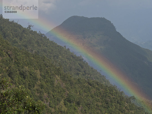 Regenbogen über einem Höhenzug nach einem Regenschauer in der Helambu-Region  Nepal  Asien