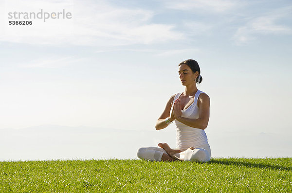 Junge Frau praktiziert Hatha-Yoga im Freien  zeigt die Stellung padmasana  Lotussitz  Nove Mesto  Okres Teplice  Tschechische Republik  Europa