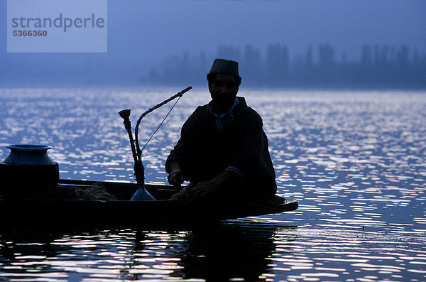 Fischer macht Pause und raucht eine Wasserpfeife am Dal-See  Srinagar  Jammu und Kaschmir  Indien  Asien