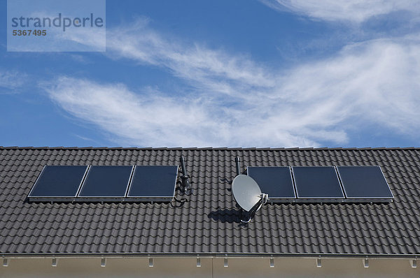 Solare Warmwasserbereitung  Absorberflächen auf Dach eines Mehrfamilienhauses  ÖffentlicherGrund