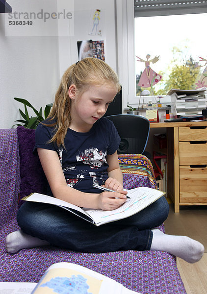 Mädchen  10 Jahre  macht in ihrem Kinderzimmer Hausaufgaben  lernt für die Schule