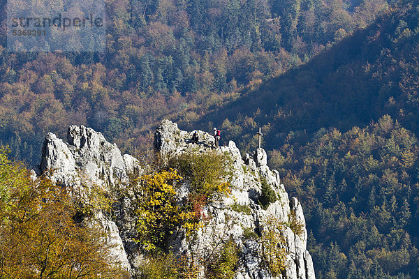 Kletterer am Gipfelkreuz des Stuhlfelsen  Naturpark Obere Donau  Landkreis Sigmaringen  Baden-Württemberg  Deutschland  Europa