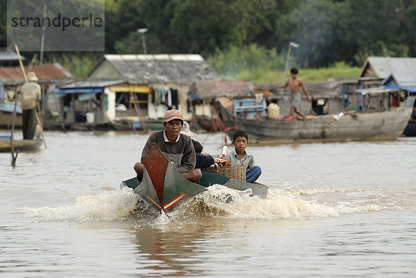 Kambodschanische Bewohner der Schwimmenden Dörfer unterwegs mit einem motorbetriebenen Langboot in voller Fahrt  Chong Khneas  Tonle Sap See  Siem Reap  Kambodscha  Indochina  Südostasien