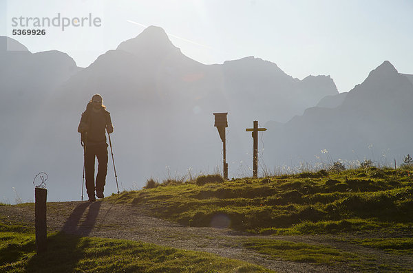 Wanderer mit Rucksack und Trekkingstöcken vor Bergkulisse unterwegs zur Gotzenalm  Schönau am Königssee  Berchtesgadener Land  Bayern  Deutschland  Europa