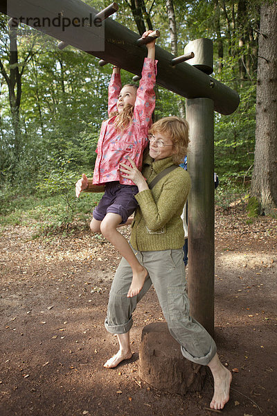 Mutter gibt turnendem Mädchen Hilfestellung  Barfußpark Egestorf  Lüneburger Heide  Niedersachsen  Deutschland  Europa