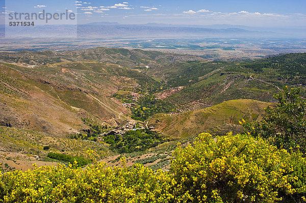 Typische Berglandschaft im Hohen Atlas  im Tal liegt eine kleine Ortschaft mit Feldern und Bäumen  Paßstraße Tizi-n-Test  Südmarokko  Marokko  Afrika