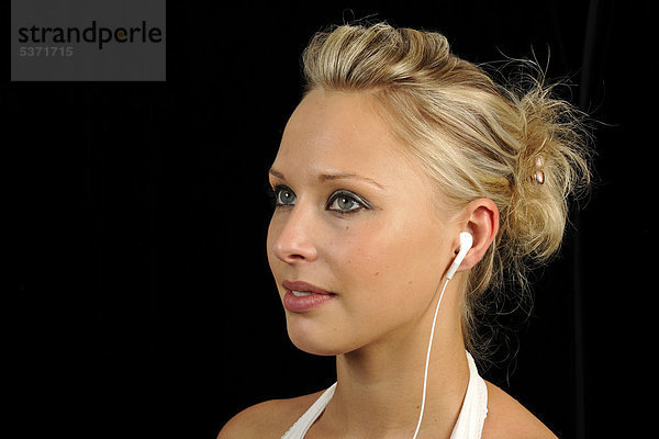Junge Frau hört Musik mit mp3-Player  Ohrhörer  Kopfhörer  Apple iPod  iPhone