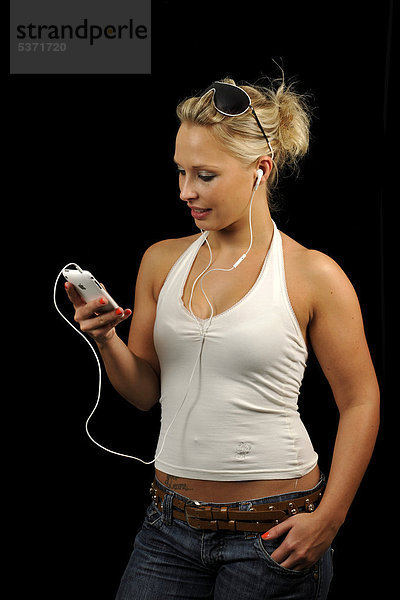 Junge Frau bedient weißes Apple iPhone  hört Musik  Ohrhörer  Kopfhörer