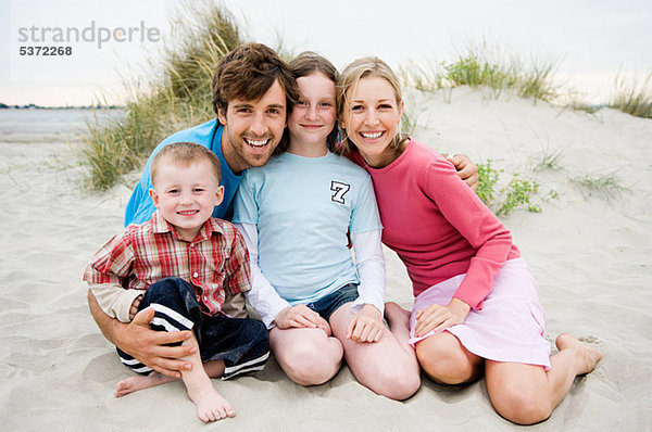 Junge Familie am Strand sitzend  Portrait