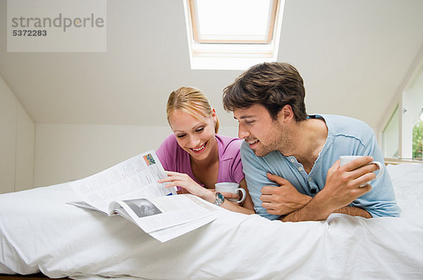 Junges Paar lesen Magazin im Bett