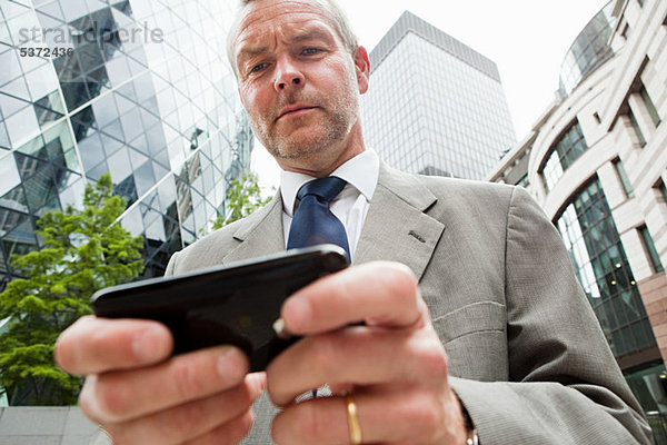 Geschäftsmann mit Smartphone und unterwegs