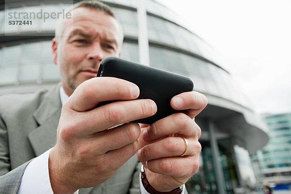 Geschäftsmann mit Smartphone im Freien