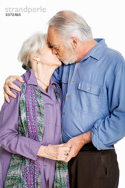 Senior Couple kissing against white background