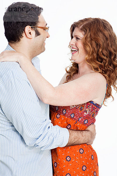 Couple embracing against white background