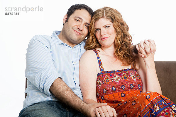 Couple relaxing auf Sofa against white background