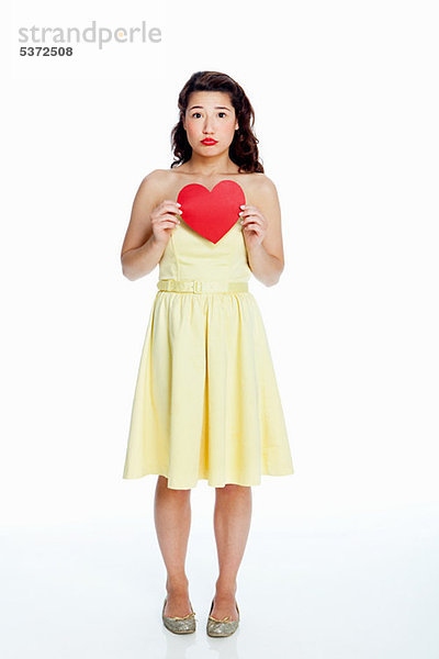 Young Woman holding Herzen Formen against white background