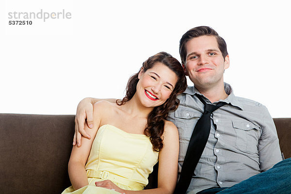 Young couple on Sofa against white background