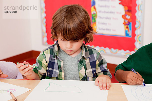 Junge zeichnen ein Bild in Klasse