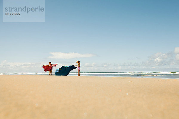 Mädchen mit decken am Strand