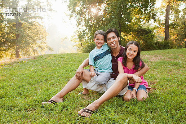Vater sitzen mit Kindern im Park  Porträt