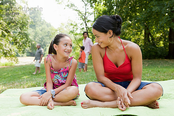 Mutter und Tochter auf Picknickdecke im park