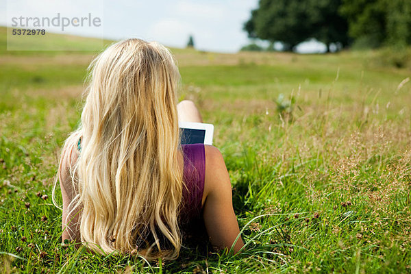 Junge Frau mit einem Handheld-Computer in einem Feld