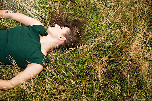 Young Woman lying down in einem Feld
