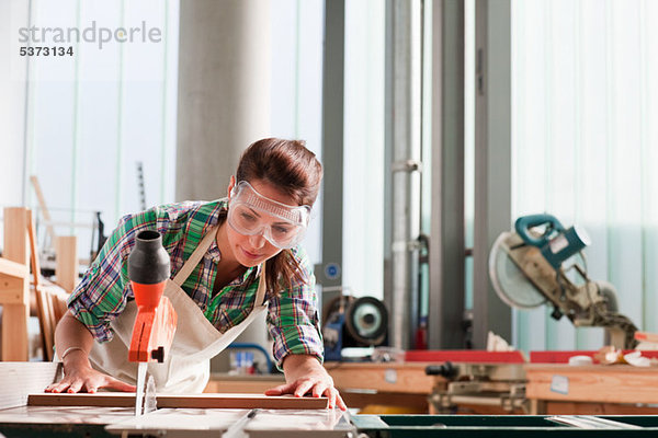 Schreiner mit Säge in der Werkstatt