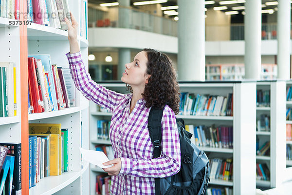 Universitätsstudent wählt Lehrbücher in der Bibliothek aus