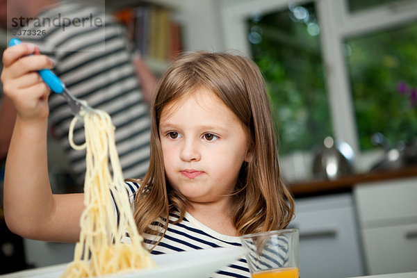 Mädchen mit Spaghetti am Tisch