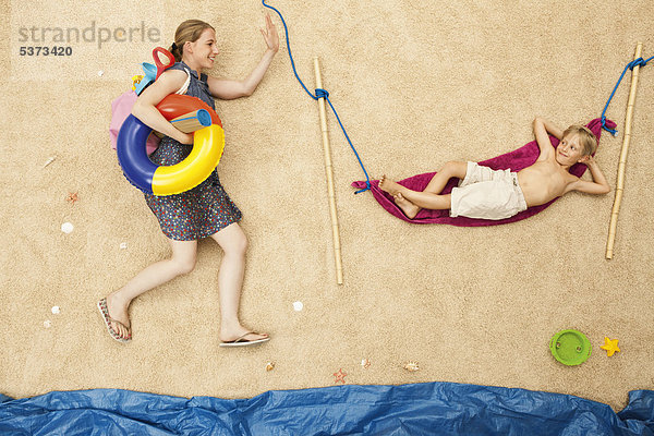 Deutschland  Mutter mit Spielzeug und Sohn in der Hängematte am Strand