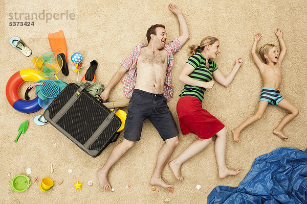 Deutschland  Familie mit Spielzeug und Gepäck am Strand