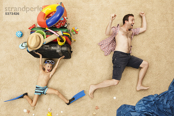 Deutschland  Vater und Sohn mit Spielzeug und Gepäck am Strand