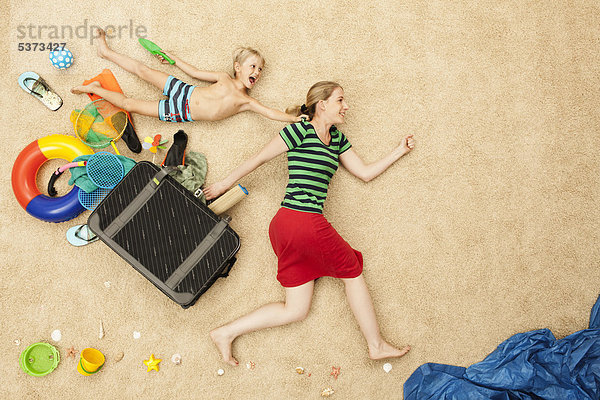 Deutschland  Mutter und Sohn mit Spielzeug und Gepäck am Strand