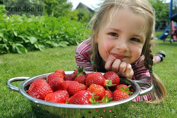 Ein Mädchen mit Erdbeeren in einer Schale