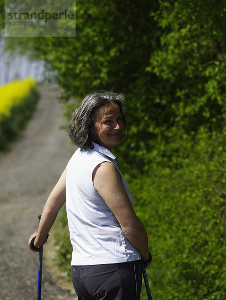 Deutschland  Reife Frau Nordic Walking  lächelnd  Portrait
