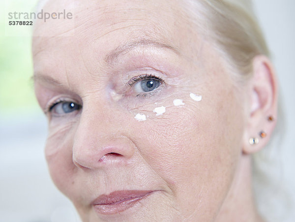 Seniorin mit Gesichtscreme im Gesicht  Portrait