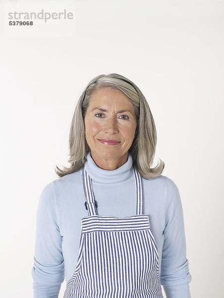 Seniorin in Küchenschürze  lächelnd  Portrait