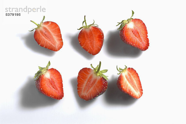 Halbgeschnittene Erdbeeren auf weißem Grund