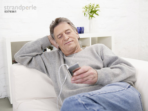 Senior Mann hört MP3-Player