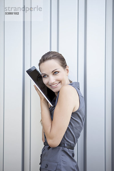 Junge Frau mit digitalem Tablett  lächelnd