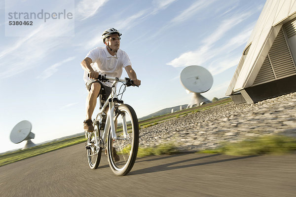 Erwachsener Mann auf dem Fahrrad in der Nähe des Radiosenders