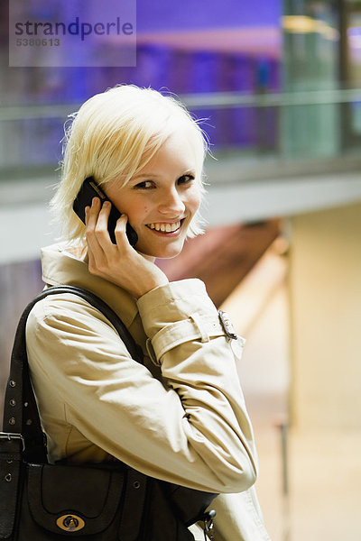 Junge Frau am Telefon  lächelnd  Portrait
