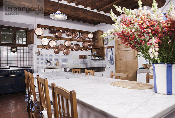 Italien  Toskana  Magliano  Blick auf Küche mit Blumen auf Esstisch