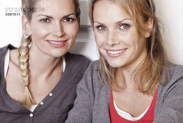 Italien  Toskana  Magliano  Zwei junge Frauen in der Küche  lächelnd  Nahaufnahme  Portrait