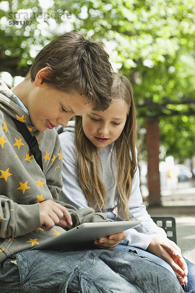 Junge und Mädchen mit digitalem Tablett